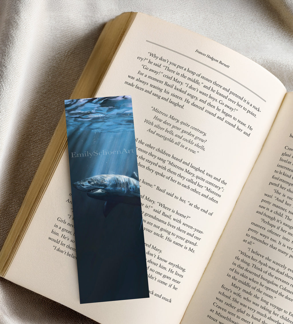Open book with a bookmark featuring a great white shark underwater